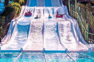 Personas deslizándose por las pistas blandas del parque acuático, una de las actividades favoritas para quienes buscan qué hacer en Aquamijas durante su visita.