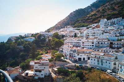 Vistas panorámicas de Mijas pueblo, con casas blancas en la ladera y montañas al fondo, un destino ideal para viajar a la Costa del Sol en verano.