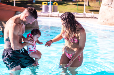 Familia disfrutando de uno de los mejores planes con niños en verano en Aquamijas, jugando en una piscina infantil durante un día de ocio familiar en la Costa del Sol.