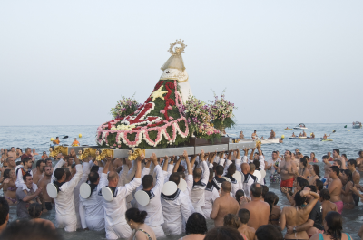 Celebración de la Virgen del Carmen en la Costa del Sol con la tradicional procesión marinera y la imagen de la patrona llevada al mar por sus portadores.